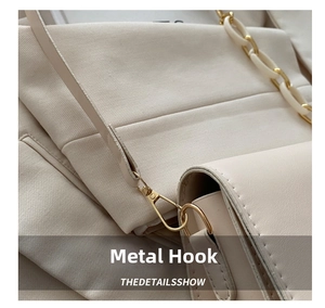 Macro detail of high-quality gold hardware hook on a stylish beige shoulder bag