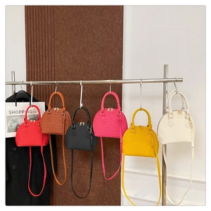 Detailed close-up of colorful faux crocodile texture shell bags with gold hardware accents