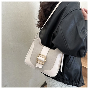 Detailed close-up of retro cream canvas and PU leather hobo bag with gold buckle