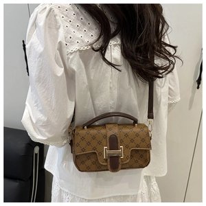 Detail of vintage crossbody bag with floral pattern shown on a model's shoulder