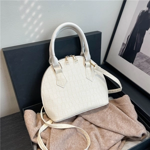Elegant white crocodile embossed shell handbag with gold hardware and shoulder strap