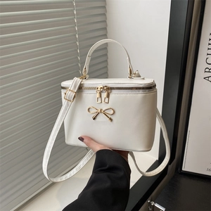 Chic white box-shaped crossbody bag with a golden bow and adjustable strap for women