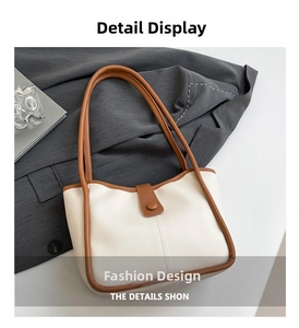 Dettaglio della borsa tote bicolore con manici in pelle marrone e chiusura magnetica