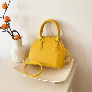Elegant yellow crocodile textured shell handbag with metallic zippers and top handle