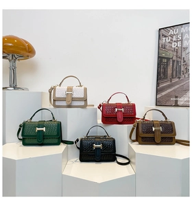 Five assorted woven texture crossbody bags with gold H-buckles on geometric pedestals