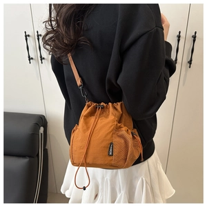 Detail of a brown nylon bucket bag featuring drawstring closure and mesh side pocket