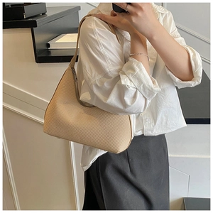 Detail of minimalist beige half-moon tote bag with fine woven texture and silver zipper