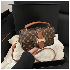 Close-up of retro color-block square bag with leather monogram pattern and gold lock
