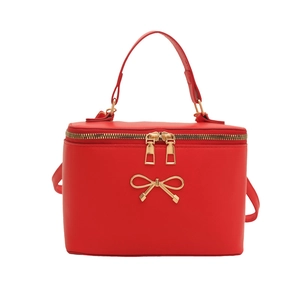 Red box-style leather handbag with golden bow accent and adjustable shoulder strap