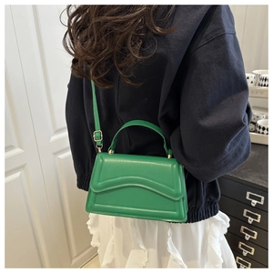 Vue détaillée du sac vert émeraude avec coutures ondulées et bandoulière réglable