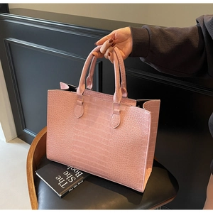 Close-up of pink crocodile texture tote bag with sturdy handles and a stylish look