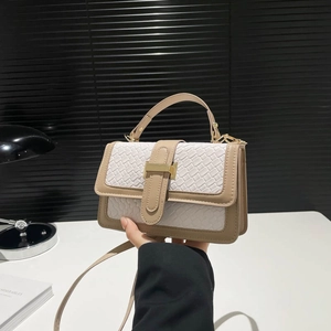 Chic beige and white woven crossbody bag with golden H buckle in office setting