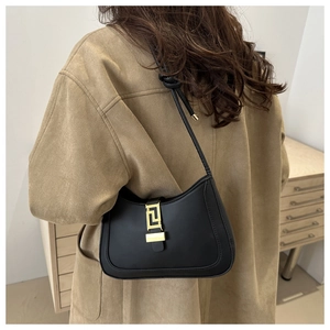 Dettaglio della borsa hobo nera a mezzaluna con fibbia in metallo dorato geometrico