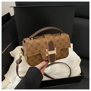 Detail view of vintage contrast color bag with floral patterns and gold metal lock clasp