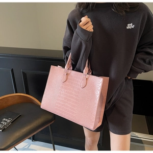 Pink croc-embossed large tote bag detail showing glossy leather texture and handles