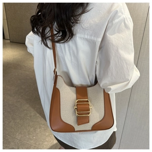 Detail of vintage canvas and brown leather contrast crossbody bag with gold metal buckle