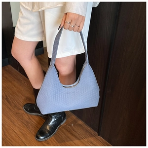 Close-up of light blue hobo bag showing diagonal embossed texture and silver zipper