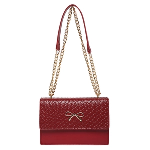 Chic red woven leather shoulder bag featuring a gold bow accent and chain strap
