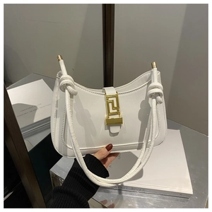 Dettaglio ravvicinato della borsa a mezzaluna in pelle bianca con fibbia dorata a chiave greca