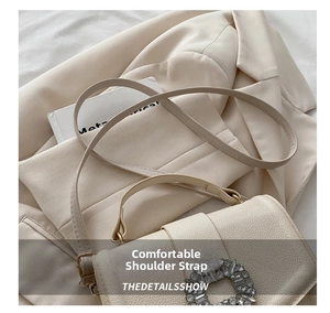 Close-up of cream lychee texture leather with a sparkling rhinestone round buckle