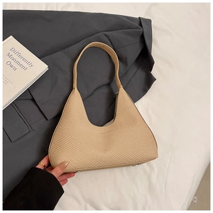 Detail of beige woven texture hobo bag with metal rivets and premium PU leather finish