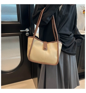 Dettaglio borsa shopper bicolore in pelle beige e finiture marroni su modella