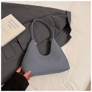 Detailed view of grey minimalist hobo bag with textured finish and silver base studs