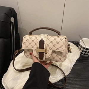Vintage patterned handbag with brown leather handles and a gold metal square buckle lock
