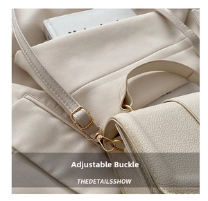Detail of adjustable metal buckle and lobster clasp on beige lychee leather bag