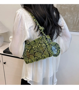 Détail d'un sac à main vert fluo motif serpent avec un petit porte-monnaie rond amovible