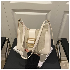 Detail of cream contrast shoulder bag featuring elegant gold metal buckle and woven texture