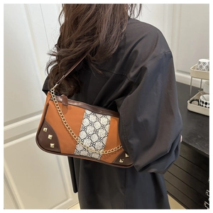 Detail of a vintage patchwork shoulder bag with leather strap and golden chain accent