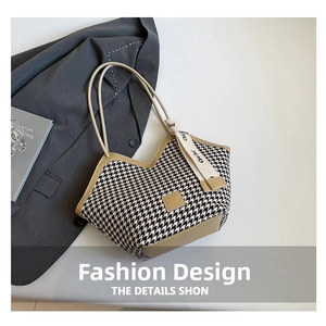 Detail of houndstooth tote bag with khaki trim, decorative ribbon and fashion magazine