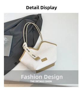 Detail of white woven tote bag with V-shaped opening and khaki webbing handle
