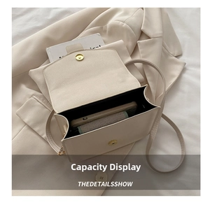 Capacity display of the cream leather crossbody bag showing space for a smartphone