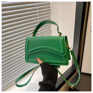 Détail du sac bandoulière vert avec surpiqûres ondulées et bandoulière réglable