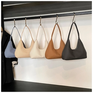 Detailed row of minimalist hobo bags in five colors with subtle woven texture on display