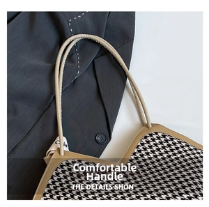Detail view of houndstooth tote bag with leather handles and contrast trim craft