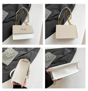 Detail showing the cream-colored woven texture and golden bow buckle of the chain bag