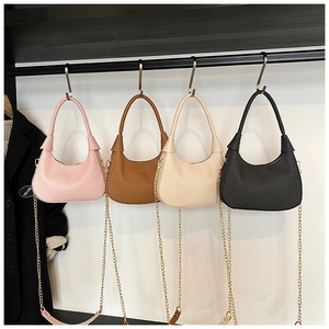 Detail showing woven texture shoulder bags in pink, brown, beige and black with metal chains