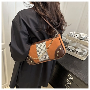 Detailed view of vintage orange and brown leather crossbody bag with gold chain strap