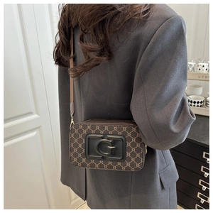 Détail du petit sac caméra marron avec motif monogramme et logo G en relief