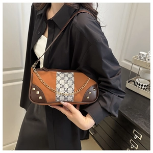 Detail of vintage baguette bag featuring brown color-blocking and gold chain accent
