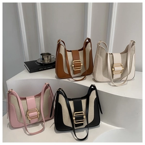 Detail showing mixed canvas and leather textures with bold gold square buckles