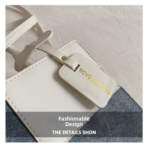 Detail of white leather and blue denim stitching with a golden Fashion Bags tag