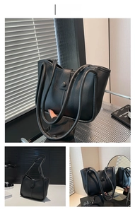Dettaglio della borsa tote minimalista in pelle nera opaca con manici cilindrici lunghi