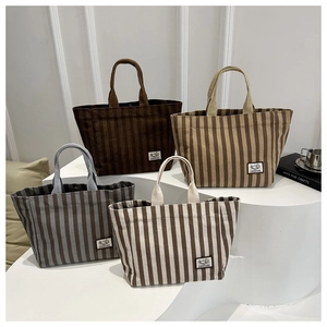 Close-up of corduroy tote bags in multiple colors with textured stripe details