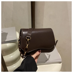 Detail of dark brown matte leather handbag with vintage resin chain and adjustable strap