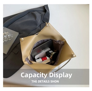 Spacious interior of beige tote bag showing laptop and makeup on grey suit background