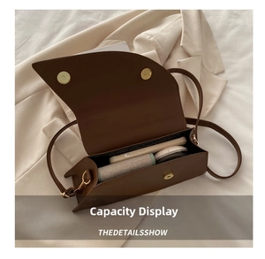 Internal view of dark brown leather crossbody bag showing capacity for phone and cosmetics